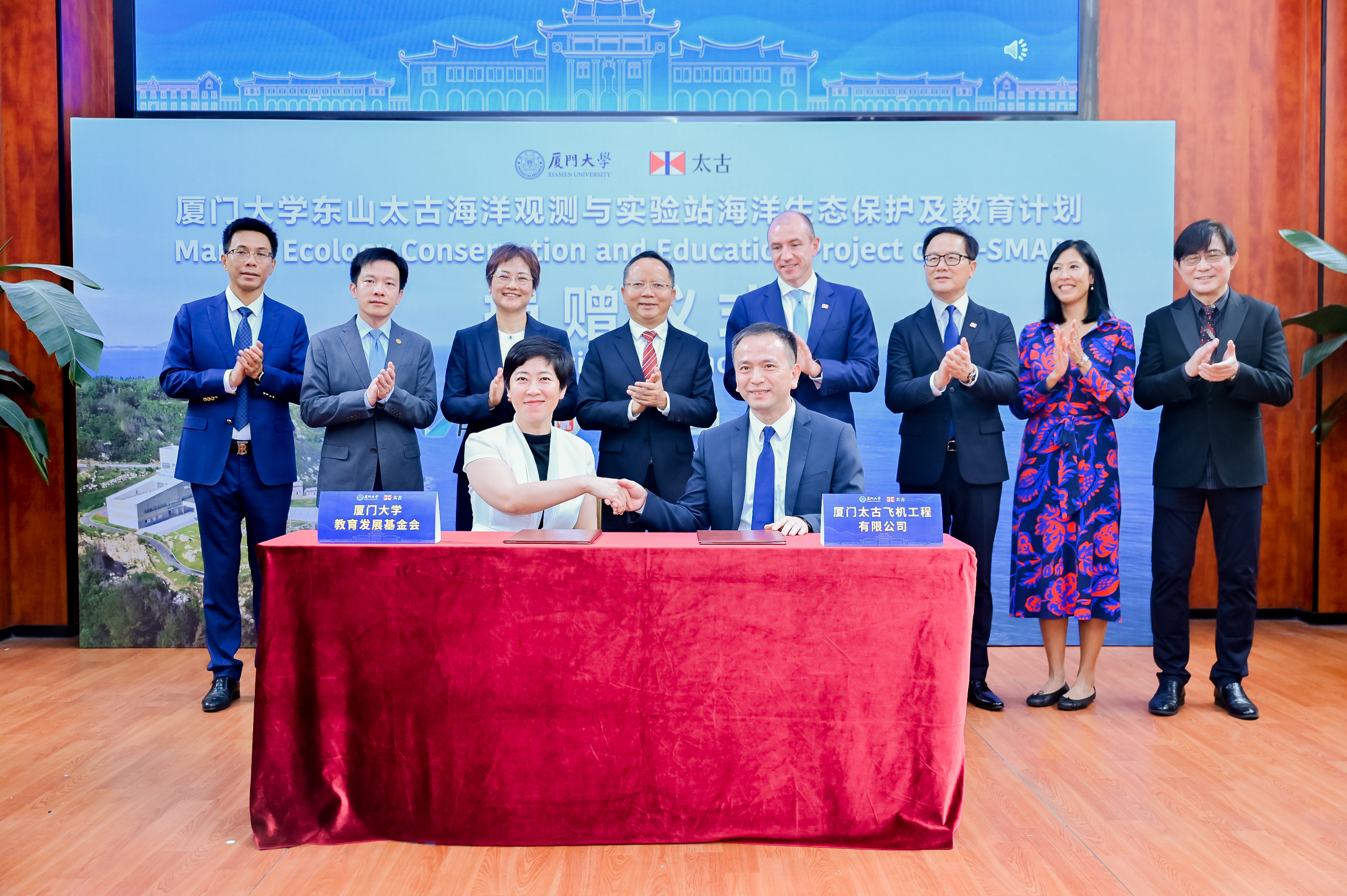 厦门太古飞机工程有限公司行政总裁官剑文(右)与厦门大学教育发展基金会秘书长赵晓慧(左)代表签署捐赠协议。见证嘉宾(后排)左至右分别为:厦门太古可口可乐饮料有限公司总经理章兴波,厦门大学副校长史大林,太古中国区主席蒋意达,厦门市人民政府副市长廖华生,香港飞机工程有限公司行政总裁、太古集团慈善理事会主席邵瑞德(Richard Sell),太古中国区董事刁志辉、香港太.jpg