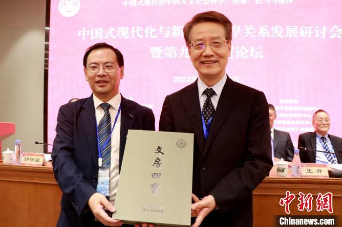 中国文化大学社科院与厦门大学台湾研究院在论坛上互换锦旗礼品。 厦大台研院供图