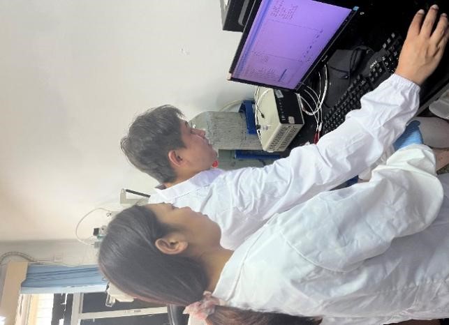 4右图:白华老师(右一)指导学生分析电化学数据.jpg