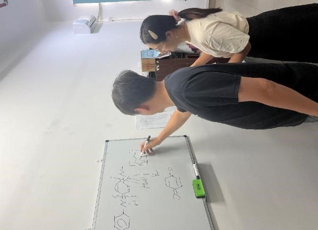 3白华老师(左一)和学生讨论高分子的反应.jpg